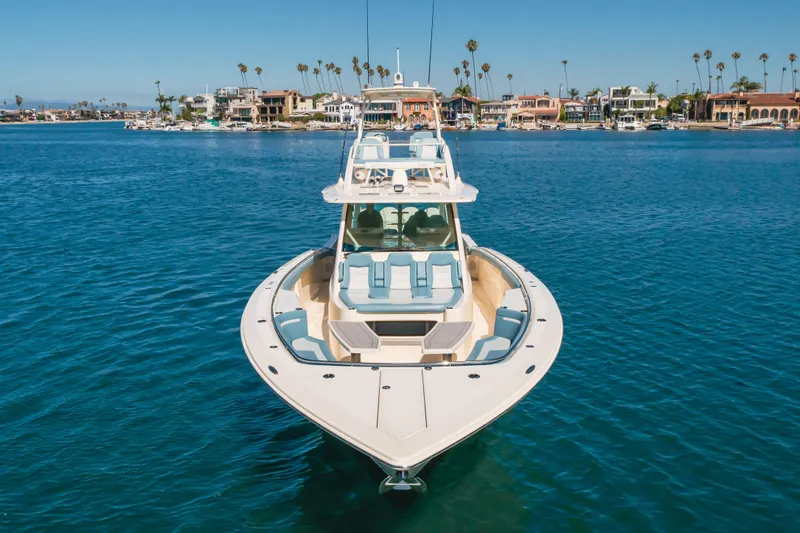 Mandalorian Yacht Photos Pics 2023 Scout 530 LXF luxury boat on calm water near coastal homes.