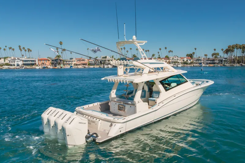 Mandalorian Yacht Photos Pics 2023 Scout 530 LXF luxury boat cruising near coastal homes and palm trees.