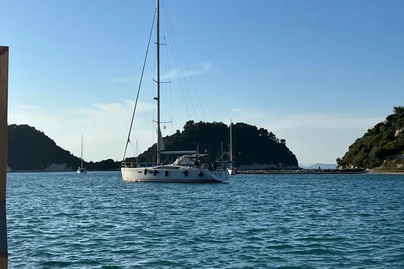  Yacht Photos Pics Sailing yacht Jeanneau 57 (2015) anchored in a scenic coastal bay.