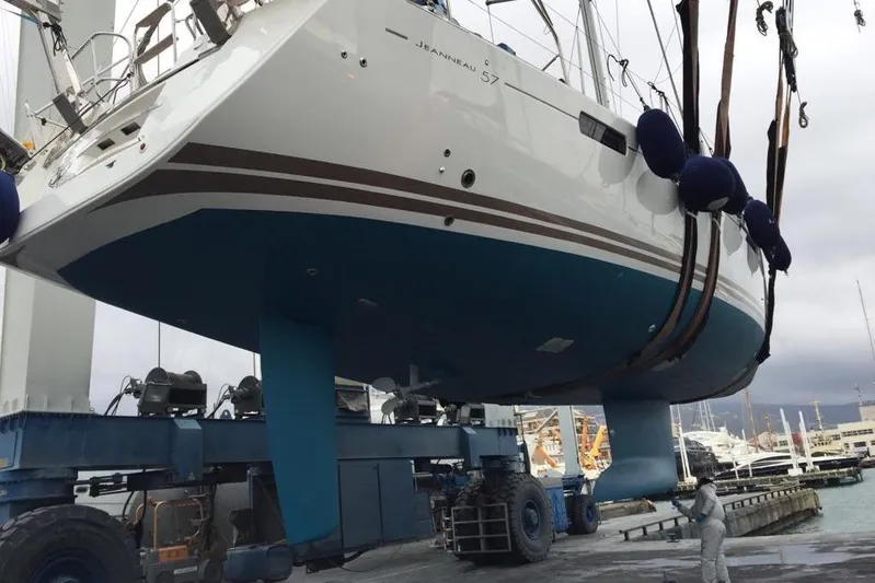  Yacht Photos Pics 2015 Jeanneau 57 yacht being lifted at a marina, showcasing its hull and keel.