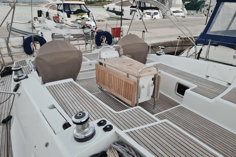  Yacht Photos Pics 2015 Jeanneau 57 sailboat deck with wooden flooring and covered helm, docked at marina.