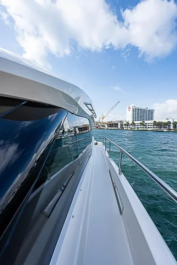  Yacht Photos Pics 2017 Carver C52 Coupe yacht on water, cityscape in background, sunny day.