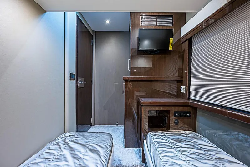  Yacht Photos Pics Interior of 2017 Carver C52 Coupe with twin beds, TV, and wooden cabinetry.