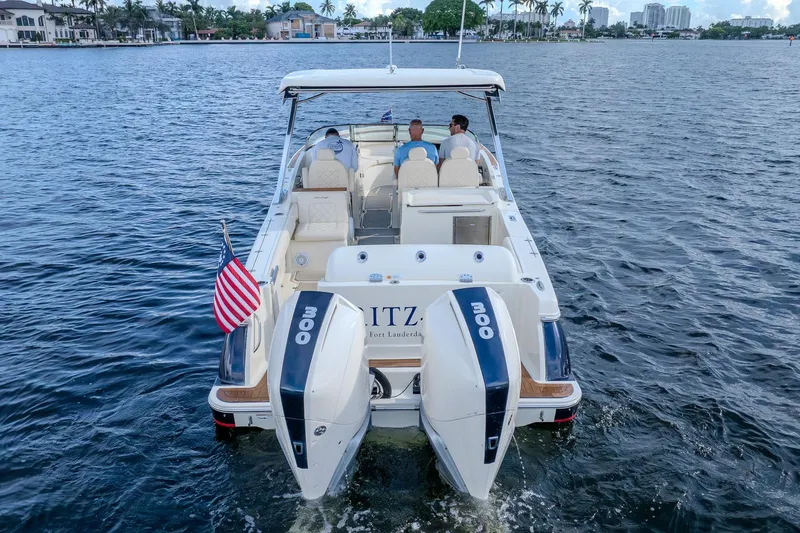 Ritz-sea Yacht Photos Pics 2019 Chris-Craft Calypso 30 boat cruising on water with three passengers and American flag.