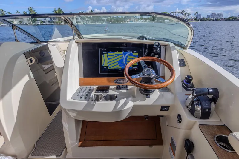 Ritz-sea Yacht Photos Pics 2019 Chris-Craft Calypso 30 helm with wooden steering wheel and navigation display.