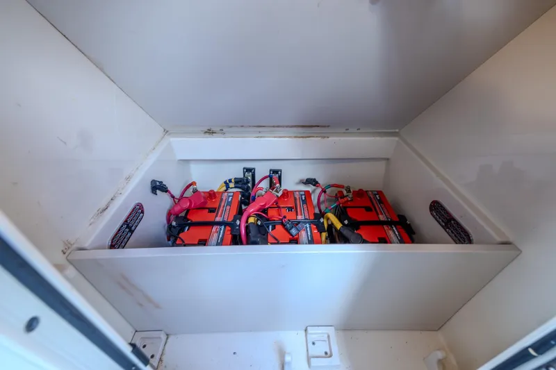 Ritz-sea Yacht Photos Pics Battery compartment of 2019 Chris-Craft Calypso 30 boat, featuring multiple red batteries.