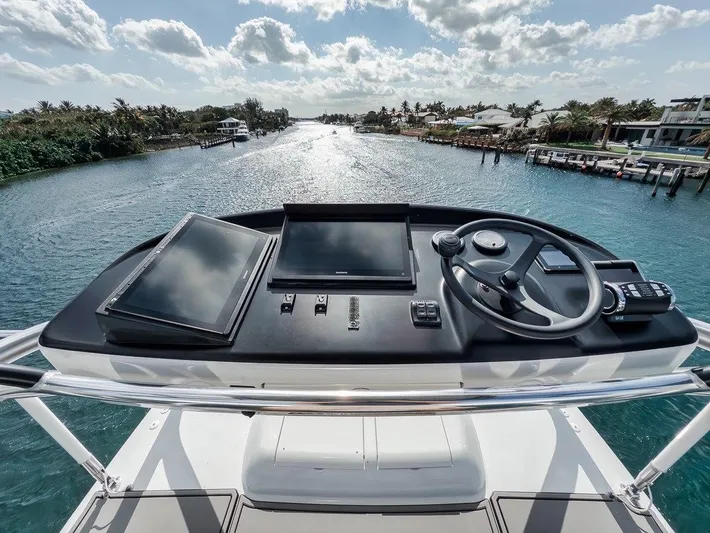 Rainmaker Yacht Photos Pics Cockpit view of 2021 Garlington Convertible yacht, featuring modern navigation equipment and scenic waterway.