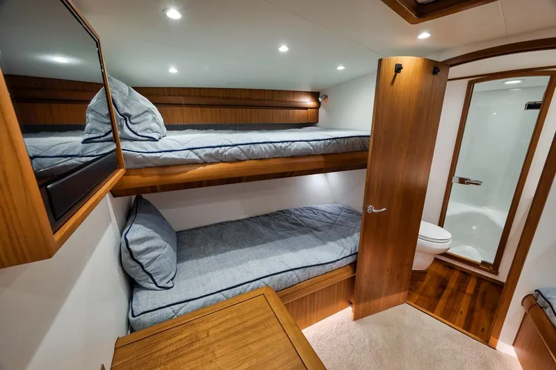 Rainmaker Yacht Photos Pics 2021 Garlington Convertible interior with bunk beds and bathroom, featuring wooden finishes.