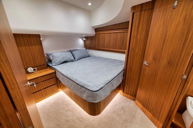 Rainmaker Yacht Photos Pics Luxurious 2021 Garlington Convertible yacht bedroom with wood paneling and cozy bedding.