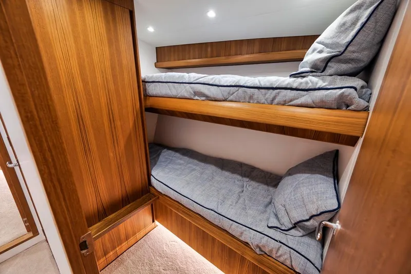 Rainmaker Yacht Photos Pics 2021 Garlington Convertible interior with wooden bunk beds and cozy bedding.