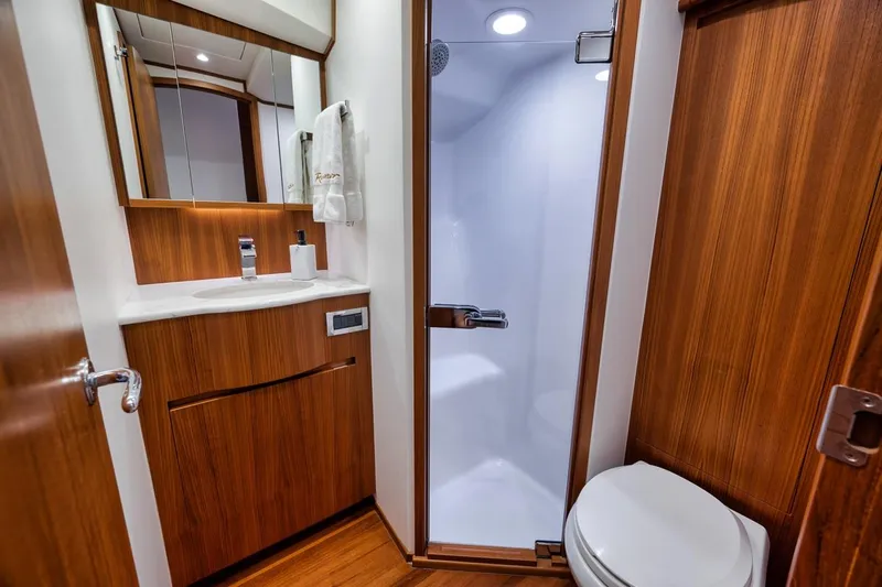 Rainmaker Yacht Photos Pics 2021 Garlington Convertible yacht bathroom with wooden cabinetry and modern fixtures.