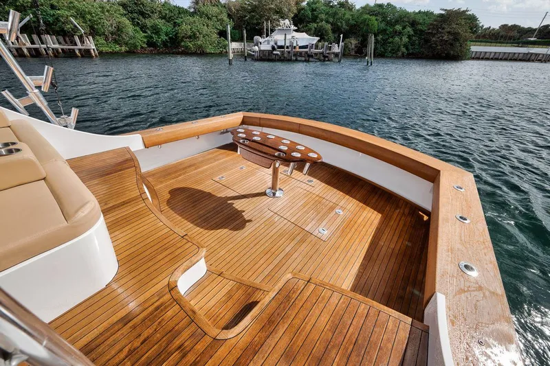 Rainmaker Yacht Photos Pics 2021 Garlington Convertible boat deck with wooden finish, docked by a serene waterfront.