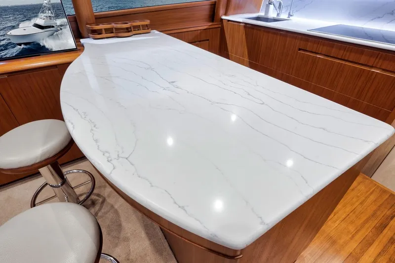 Rainmaker Yacht Photos Pics Luxurious kitchen interior of 2021 Garlington Convertible yacht with marble countertop and wooden cabinetry.