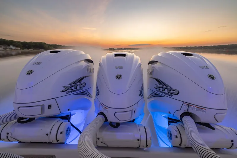  Yacht Photos Pics Triple outboard engines on a 2021 Jupiter 41 SB at sunset, with blue LED lighting.