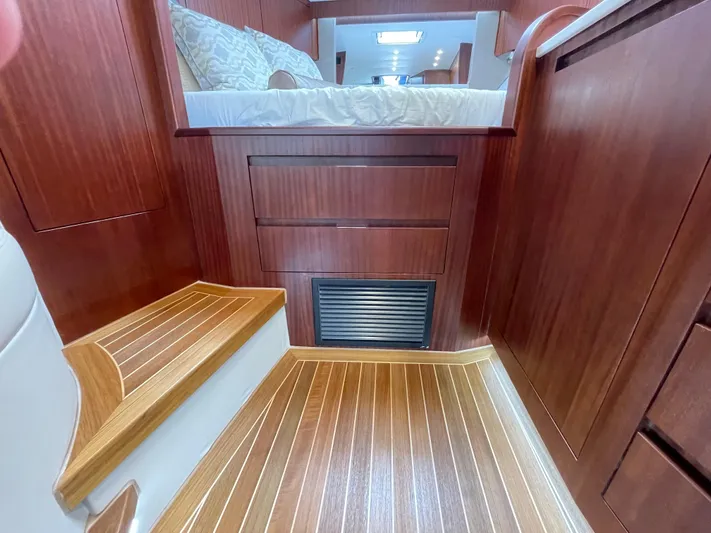  Yacht Photos Pics Luxurious interior of 2021 Jupiter 41 SB yacht with wooden flooring and cozy bedding.