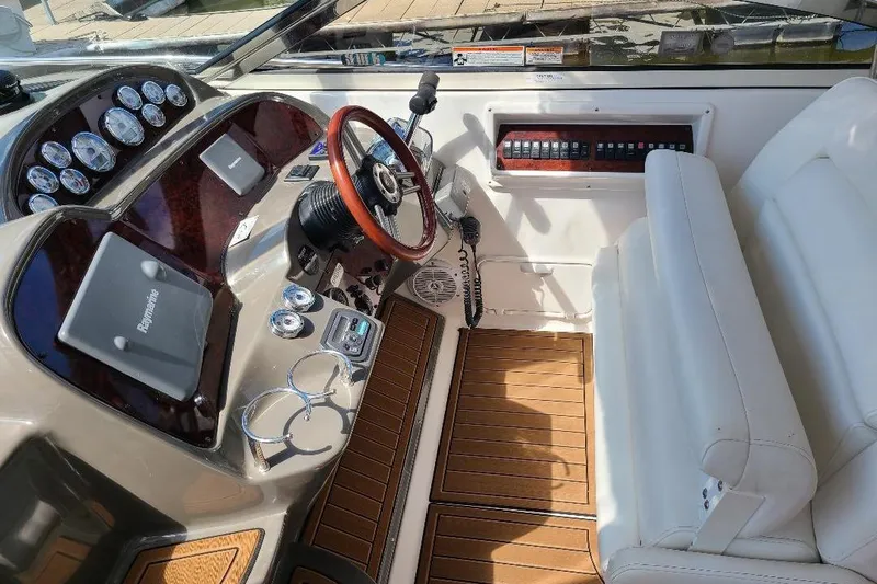  Yacht Photos Pics 2009 Regal Commodore 3760 IB boat cockpit with steering wheel, gauges, and white seating.