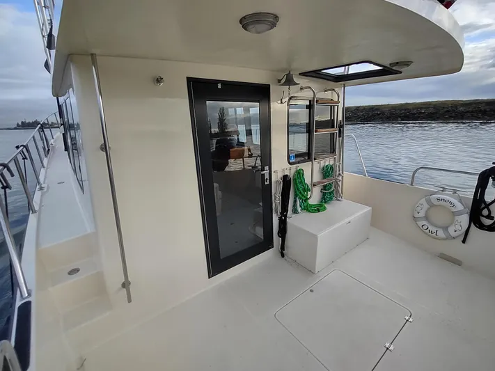 Snowy Owl Yacht Photos Pics Nordic Tug 42, 2000 model, deck view with door and seating, near water.