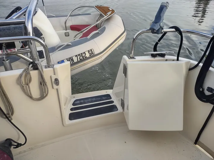 Snowy Owl Yacht Photos Pics Nordic Tug 42 boat deck with inflatable dinghy, 2000 model, docked on calm water.