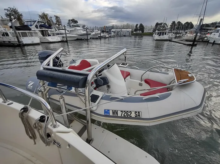 Snowy Owl Yacht Photos Pics Nordic Tug 42 (2000) docked with inflatable boat, marina background, overcast sky.
