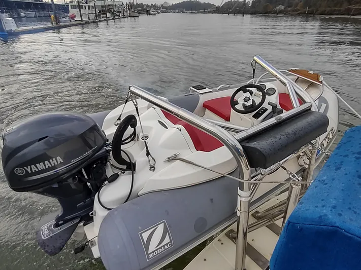 Snowy Owl Yacht Photos Pics Zodiac inflatable boat with Yamaha motor on Nordic Tug 42, 2000 model, docked on calm water.