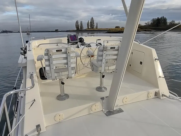 Snowy Owl Yacht Photos Pics Nordic Tug 42 boat deck with dual helm seats, 2000 model, on calm water.