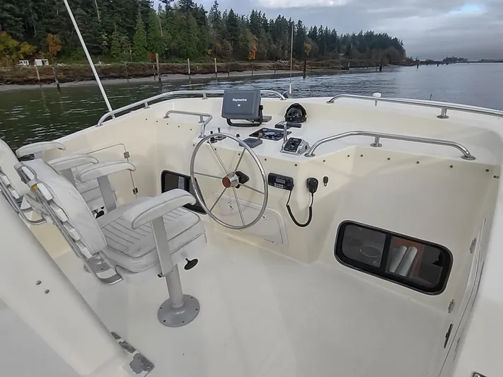 Snowy Owl Yacht Photos Pics 2000 Nordic Tug 42 helm with dual seats, steering wheel, and navigation equipment.