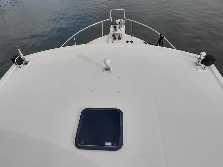 Snowy Owl Yacht Photos Pics Nordic Tug 42 (2000) bow view, featuring deck details and calm water backdrop.