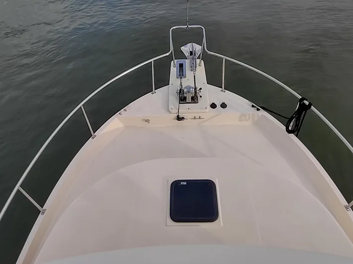 Snowy Owl Yacht Photos Pics Nordic Tug 42 (2000) bow view, featuring deck and railing on calm water.