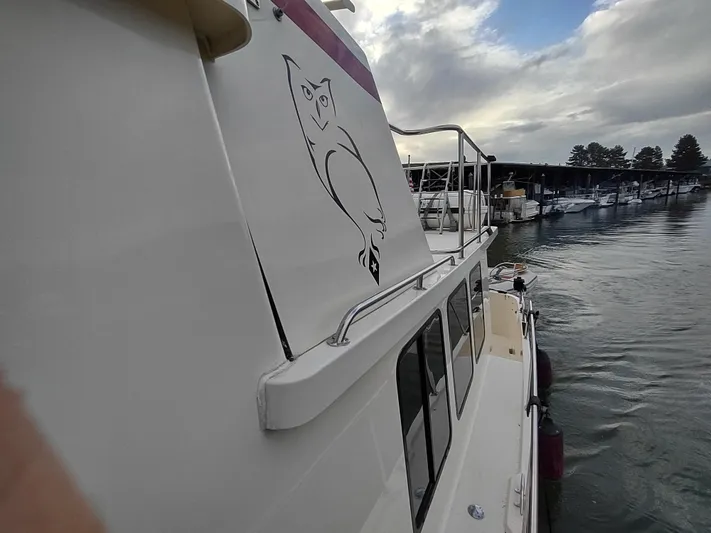 Snowy Owl Yacht Photos Pics Nordic Tug 42 boat, 2000 model, docked with owl graphic on side.