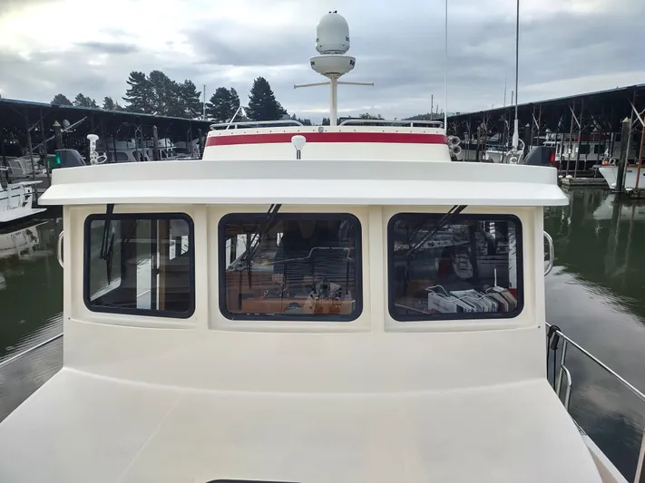 Snowy Owl Yacht Photos Pics 2000 Nordic Tug 42 docked at marina, front view with windows and radar.