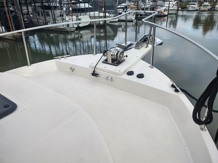 Snowy Owl Yacht Photos Pics Nordic Tug 42 (2000) bow view with winch, docked in marina.