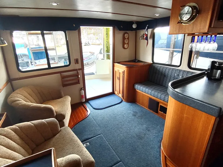 Snowy Owl Yacht Photos Pics Cozy interior of 2000 Nordic Tug 42 with plush seating and wooden accents.