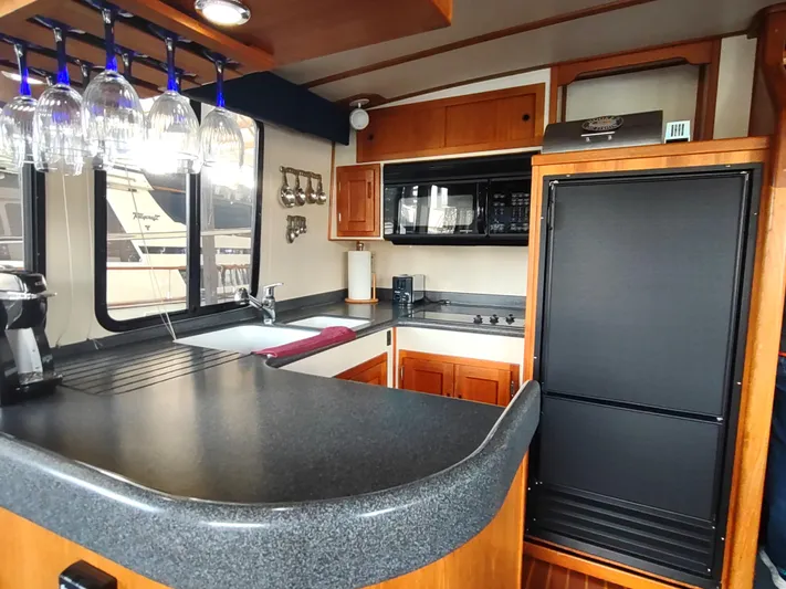 Snowy Owl Yacht Photos Pics Nordic Tug 42 yacht kitchen, 2000 model, featuring modern appliances and elegant wood cabinetry.