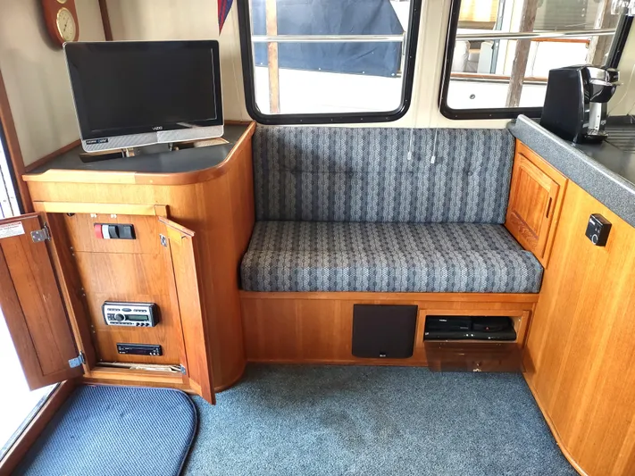Snowy Owl Yacht Photos Pics Interior of 2000 Nordic Tug 42 with TV, seating, and wooden cabinetry.