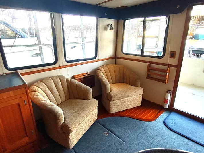 Snowy Owl Yacht Photos Pics Cozy interior of 2000 Nordic Tug 42 with plush chairs and wooden accents.