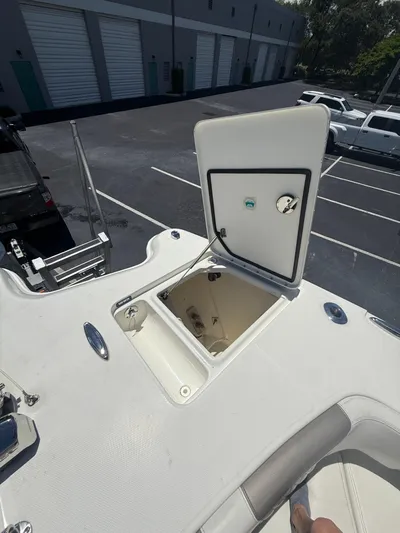  Yacht Photos Pics 2023 World Cat 325 CC boat with open storage compartment in a parking lot.