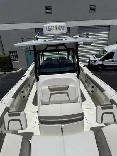  Yacht Photos Pics 2023 World Cat 325 CC boat with seating, docked near a warehouse.