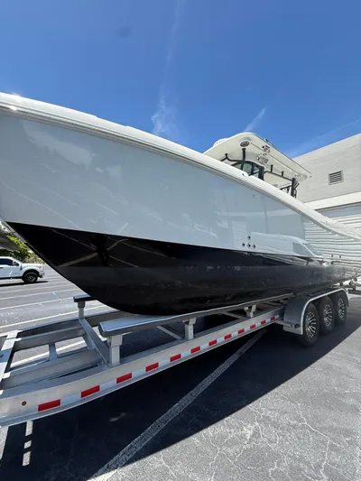  Yacht Photos Pics 2023 World Cat 325 CC boat on a trailer in a parking lot.