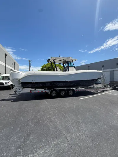  Yacht Photos Pics 2023 World Cat 325 CC boat on trailer in parking lot under clear sky.