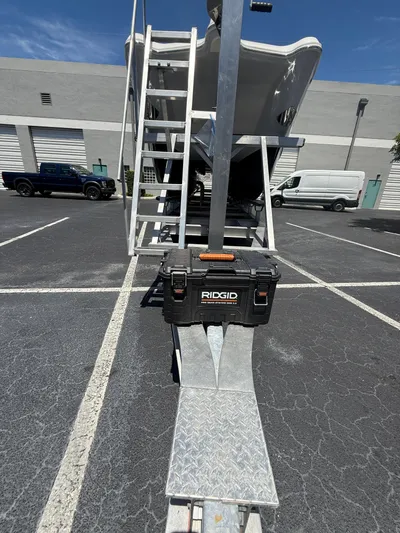  Yacht Photos Pics 2023 World Cat 325 CC boat on trailer with ladder and RIDGID toolbox in parking lot.