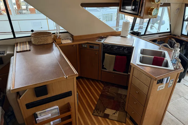  Yacht Photos Pics Interior of 1999 Bayliner 3988 Command Bridge Motoryacht kitchen with wood cabinetry and dual sink.