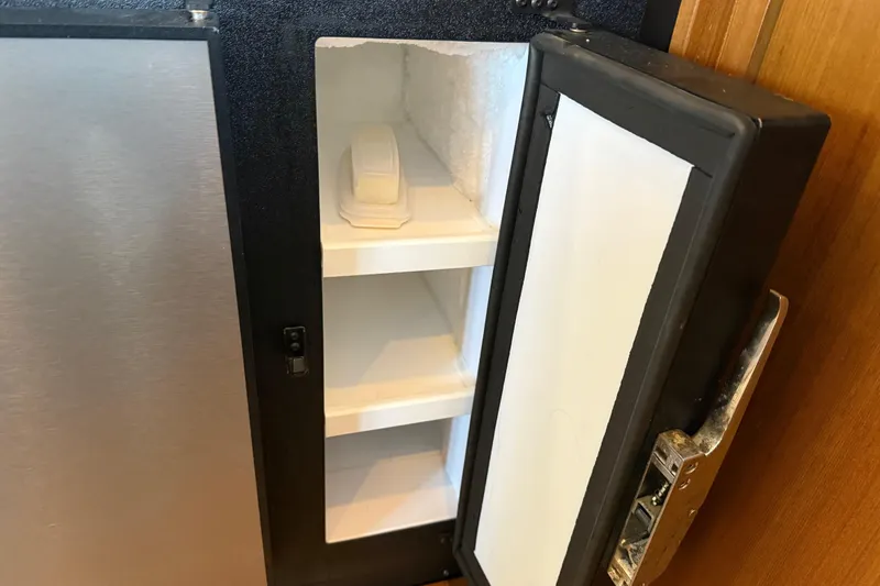  Yacht Photos Pics Open refrigerator on 1999 Bayliner 3988 Command Bridge Motoryacht, showing empty shelves and a butter dish.