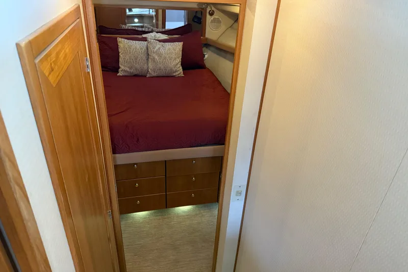  Yacht Photos Pics 1999 Bayliner 3988 Command Bridge Motoryacht bedroom with red bedding and wooden cabinetry.