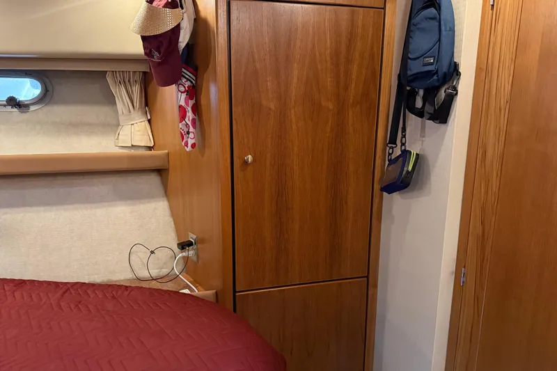  Yacht Photos Pics Interior of 1999 Bayliner 3988 Command Bridge Motoryacht with wooden cabinetry and red bedding.