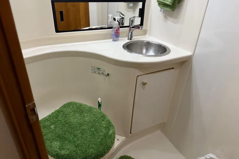  Yacht Photos Pics 1999 Bayliner 3988 Command Bridge Motoryacht bathroom with sink and green carpeted toilet seat.