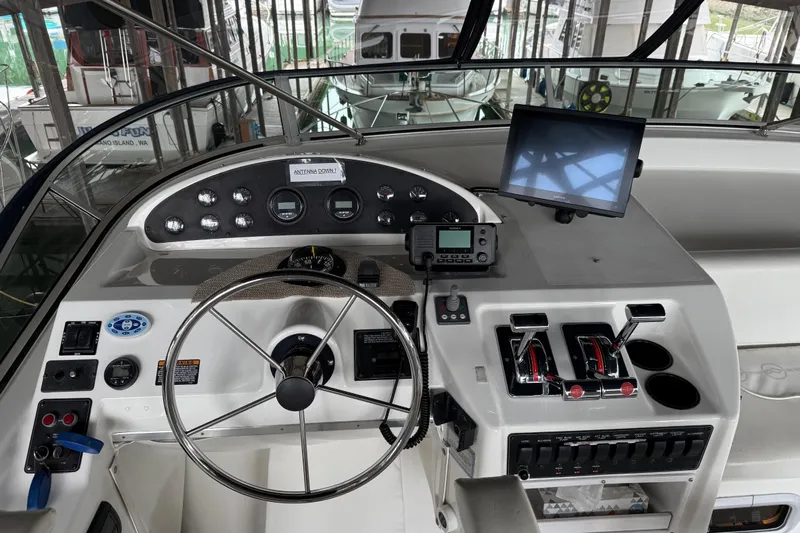  Yacht Photos Pics 1999 Bayliner 3988 Command Bridge Motoryacht helm with steering wheel, controls, and navigation equipment.