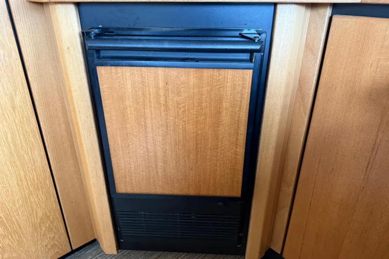 Yacht Photos Pics Built-in refrigerator on 1999 Bayliner 3988 Command Bridge Motoryacht, wood paneling.