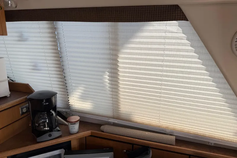  Yacht Photos Pics Interior of 1999 Bayliner 3988 yacht with blinds, coffee maker, and wooden cabinetry.