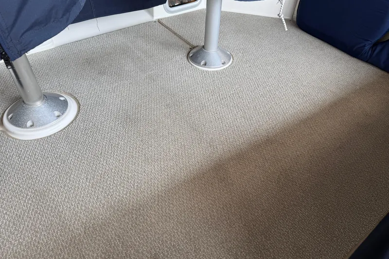  Yacht Photos Pics Carpeted interior of 1999 Bayliner 3988 Command Bridge Motoryacht, featuring metal table supports.