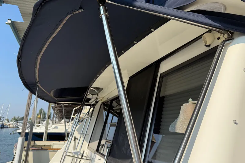  Yacht Photos Pics 1999 Bayliner 3988 Command Bridge Motoryacht with canopy and bell, docked at marina.